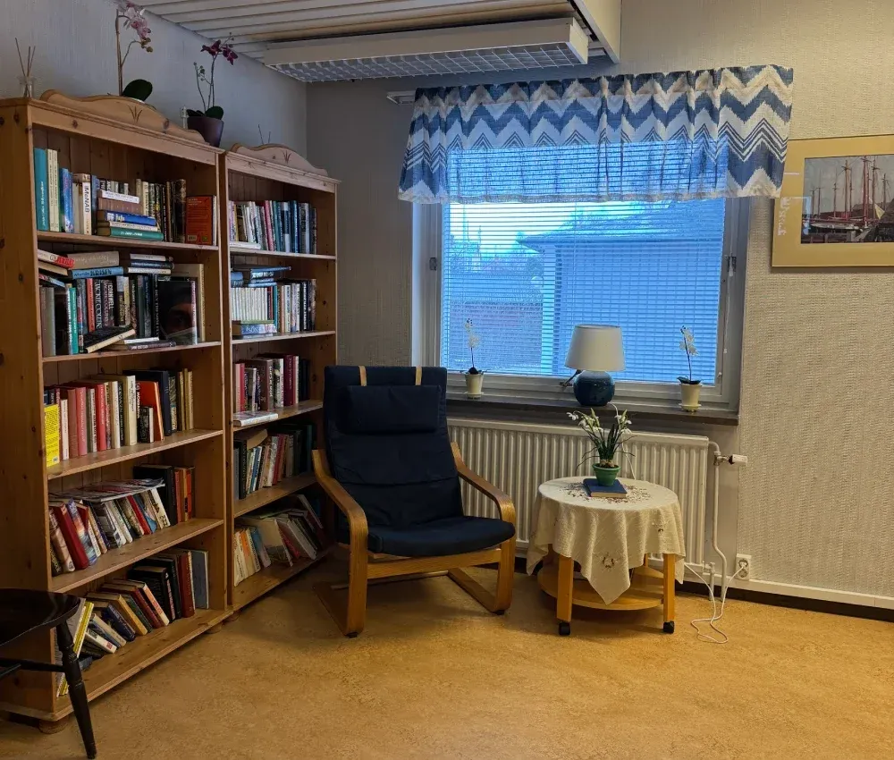 Bokhyllor och läsfåtölj i allrummet
