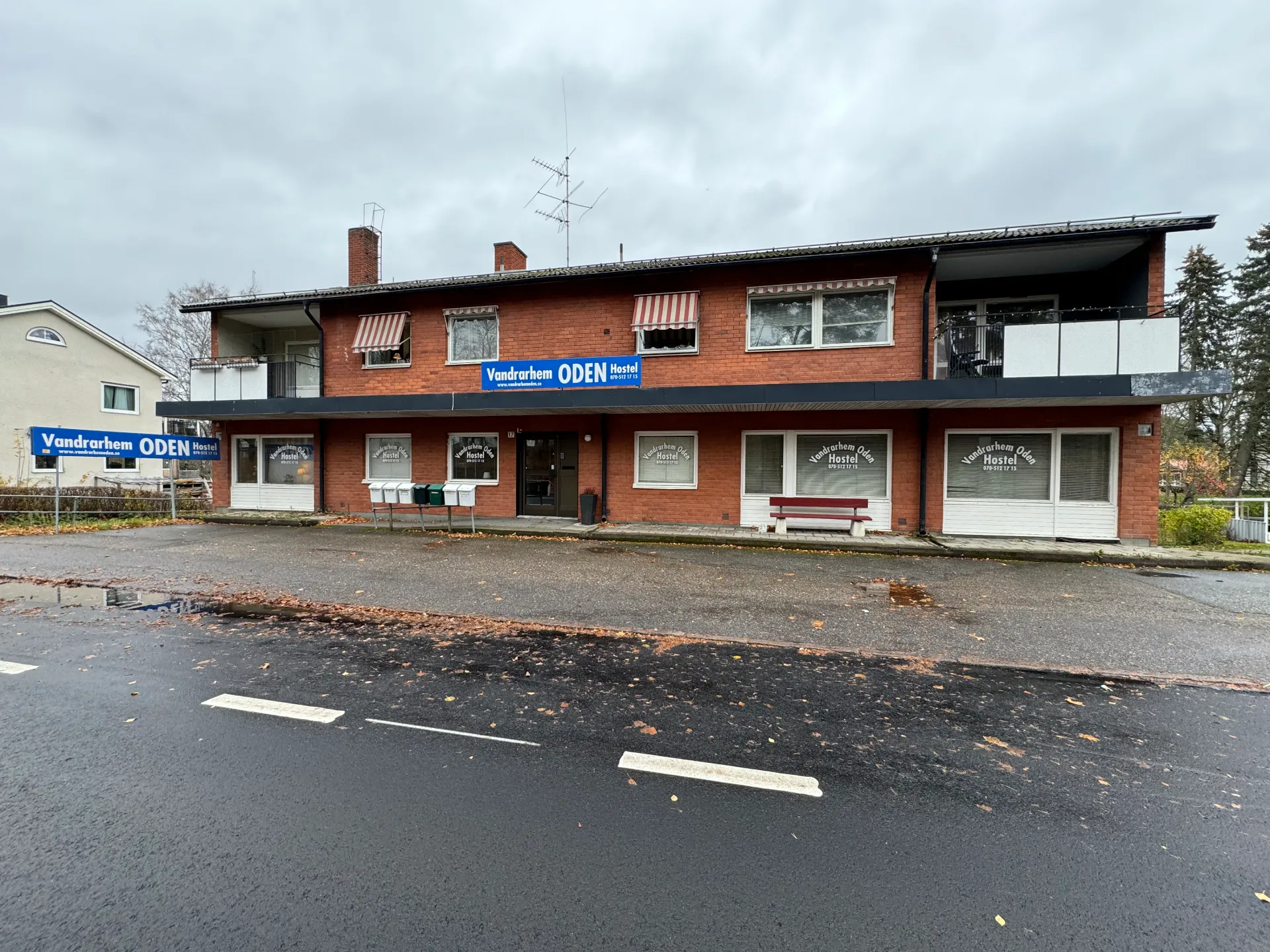 Vandrarhem Oden på Örebrovägen 17 – tegelhus med blå skylt "Vandrarhem ODEN Hostel"